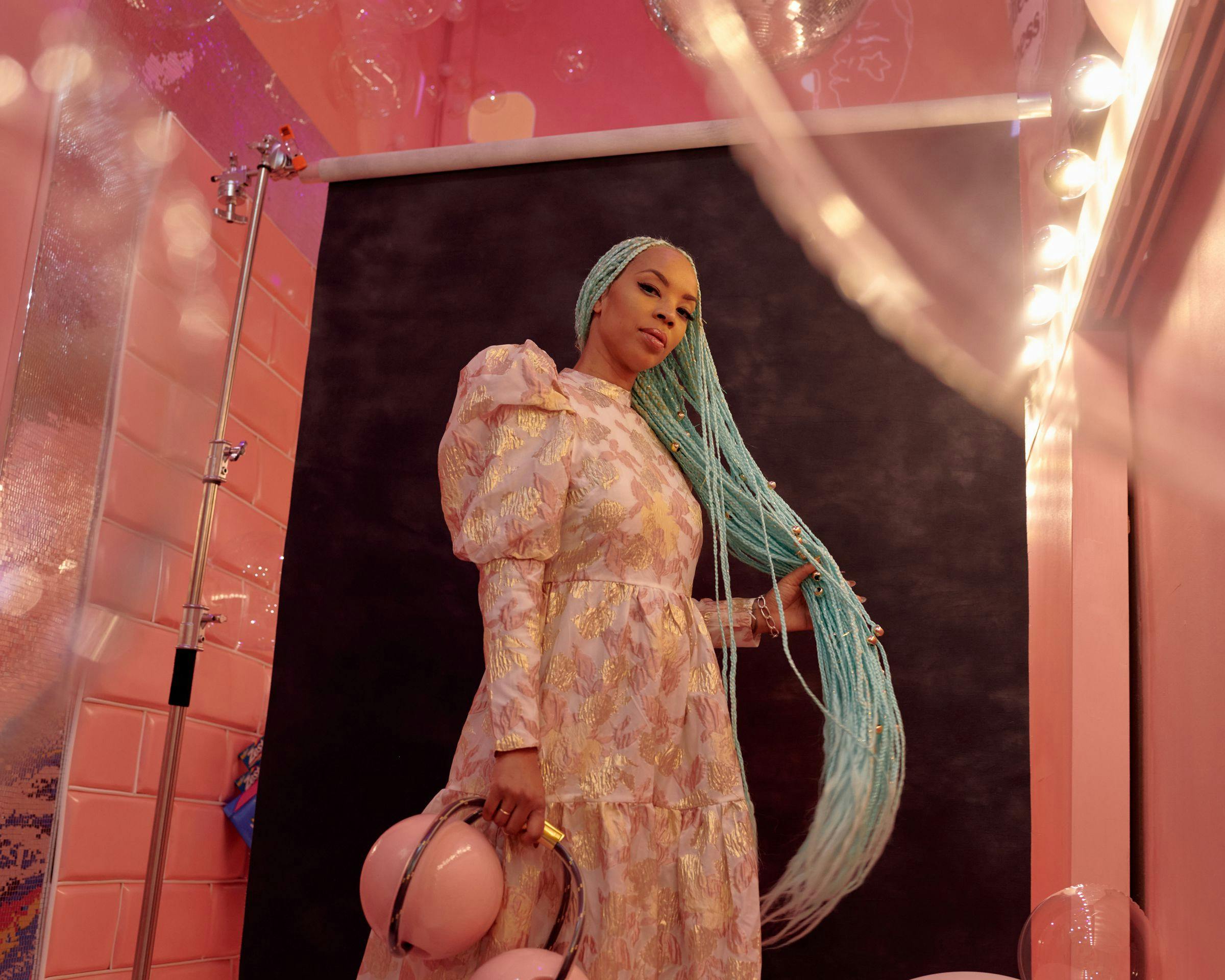 Woman with blue hair in a pink room